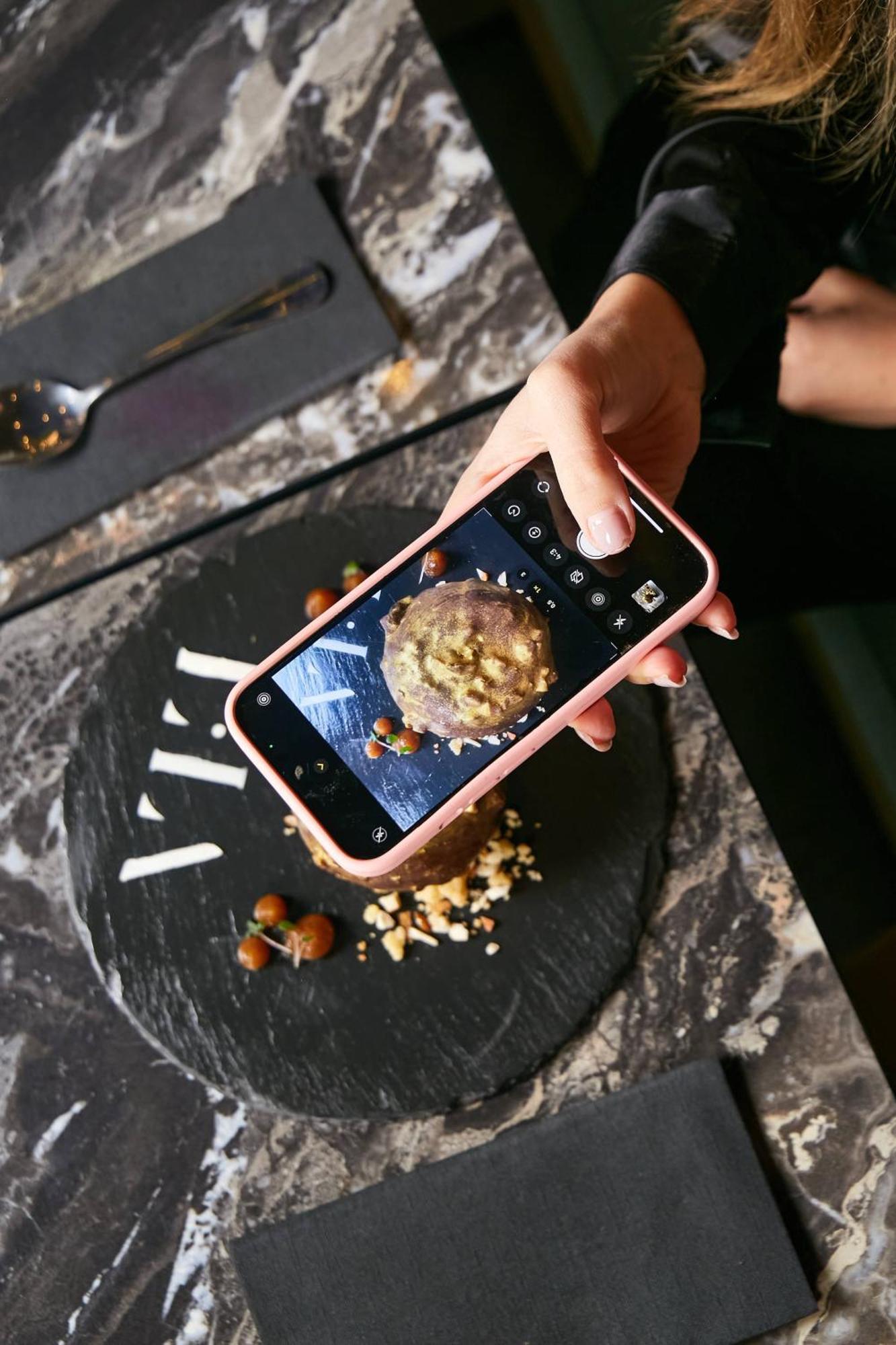 Pullman Santiago El Bosque Hotel Bagian luar foto A smartphone being used to take a photograph of a food item